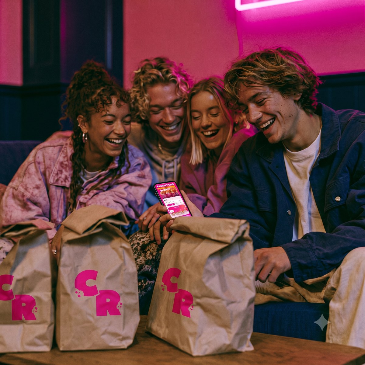 Des amis autour d'un smartphone avec l'app Crousty Rice et leurs sacs de commande